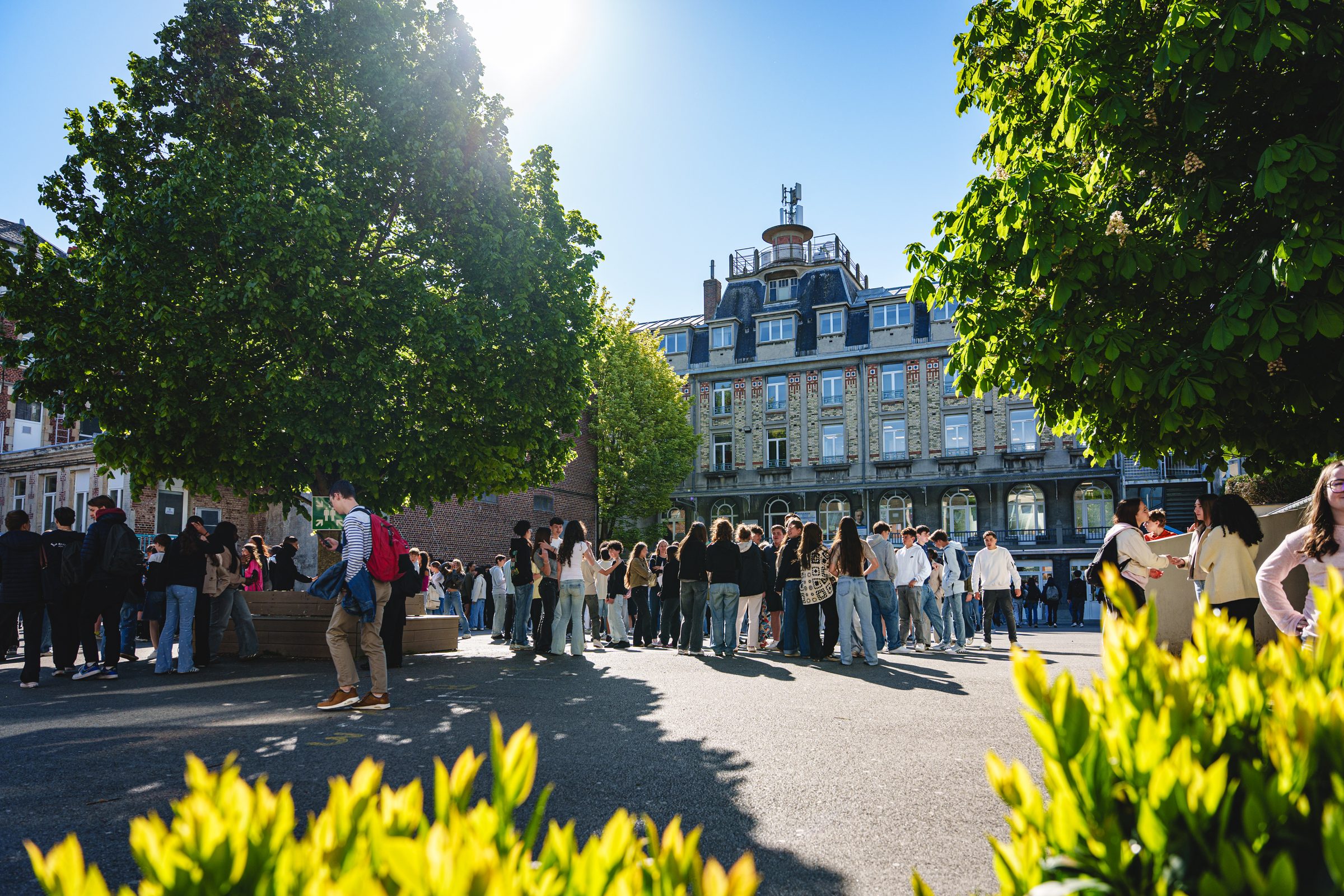 Élèves du collège-lycée rassemblés dans la cour devant les bâtiments de l'établissement