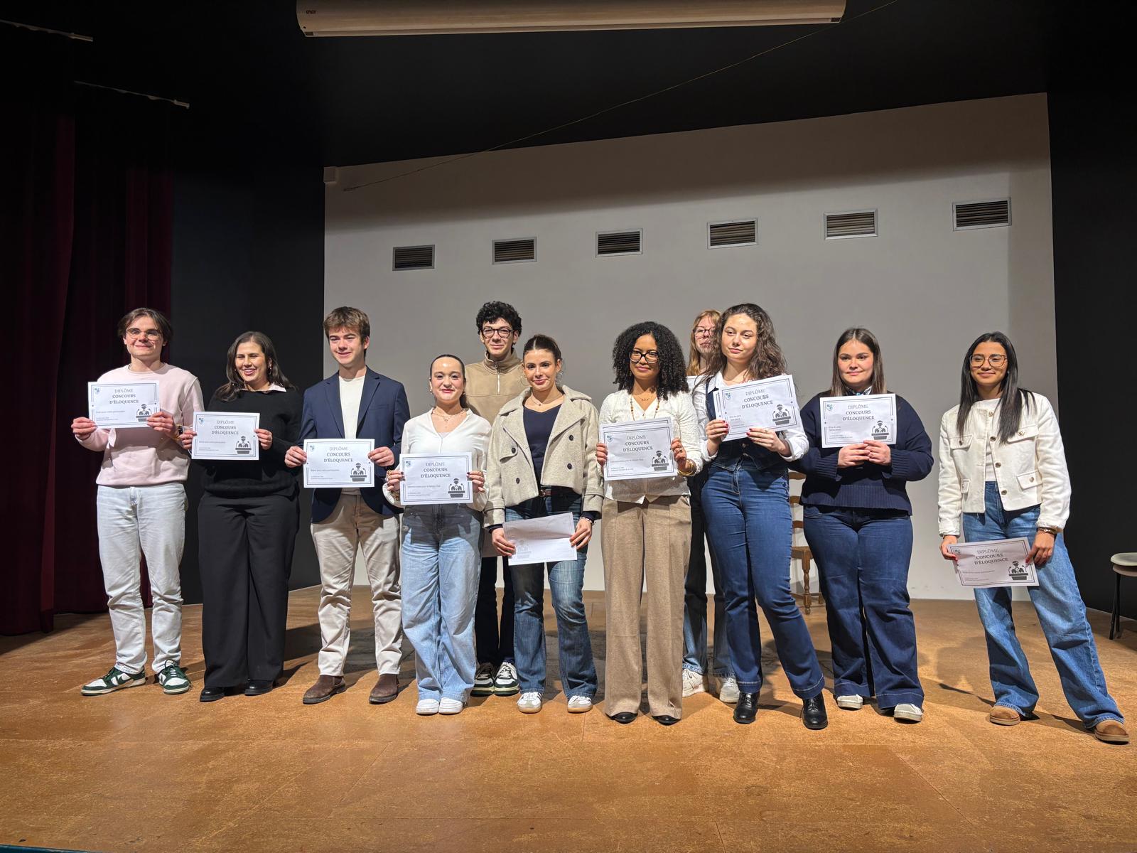 Lycéens récompensés par un certificat lors d'un concours d'éloquence, sur scène