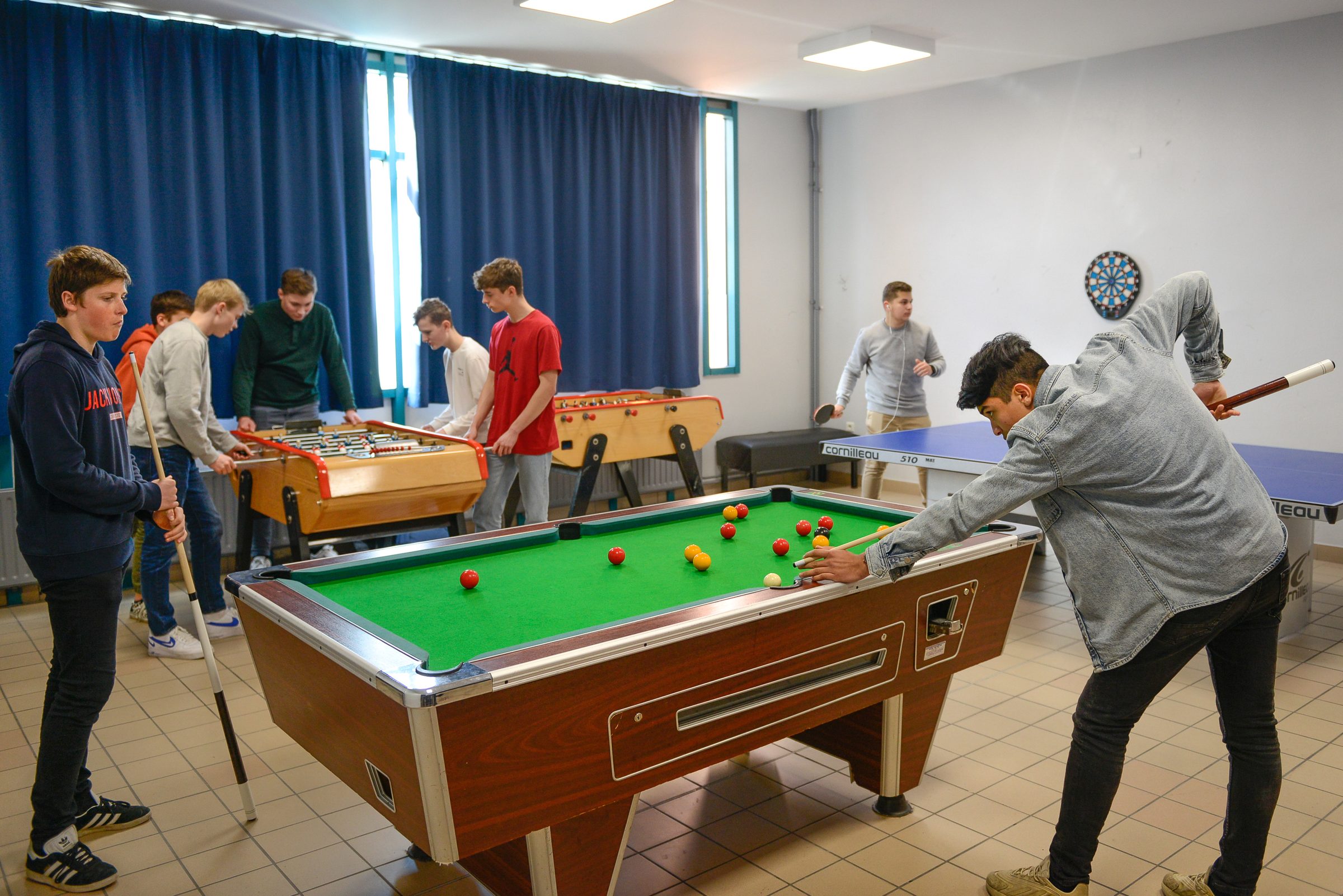 Lycéens dans la salle de détente avec billard, baby-foot et tennis de table