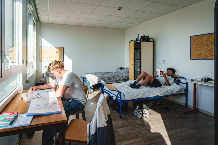 Internes détendus sur leurs lits dans une chambre de l'internat