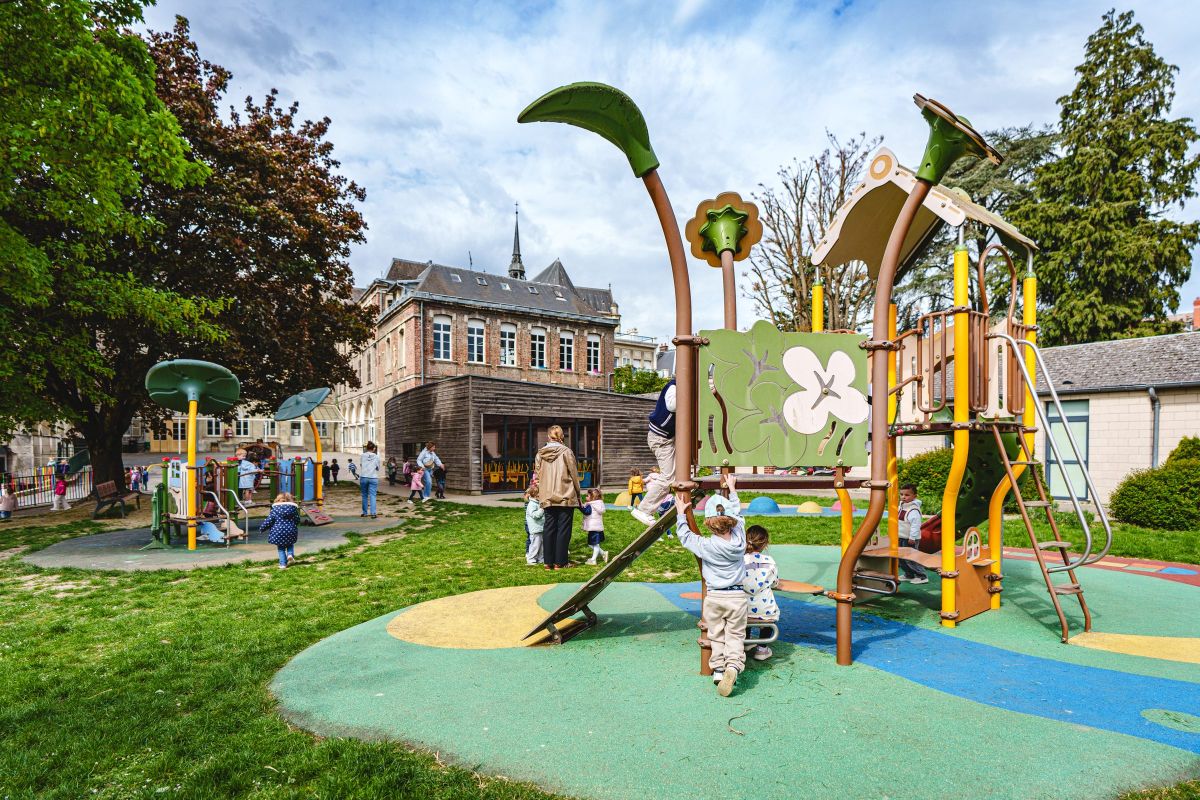 Enfants jouant dans la cour de récréation de l'école, jeux en bois au premier plan