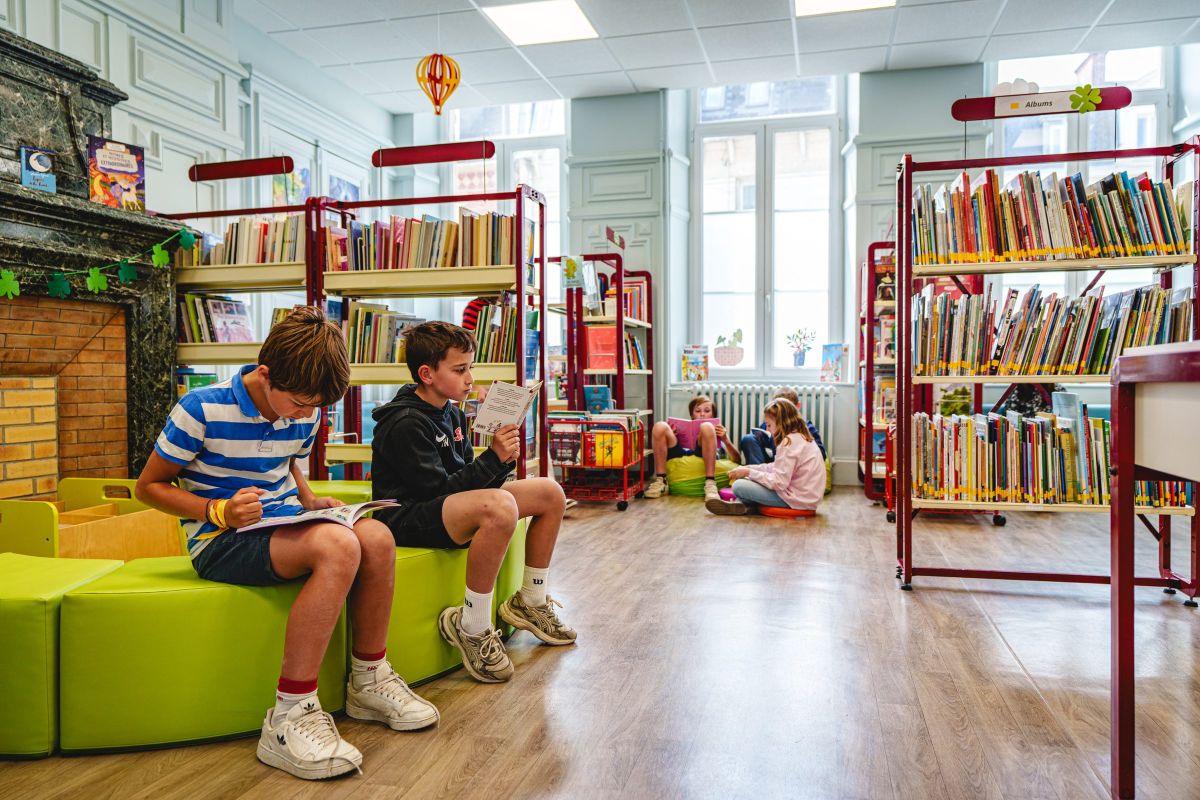 Élèves installés au centre de documentation de l'école pour un temps de lecture