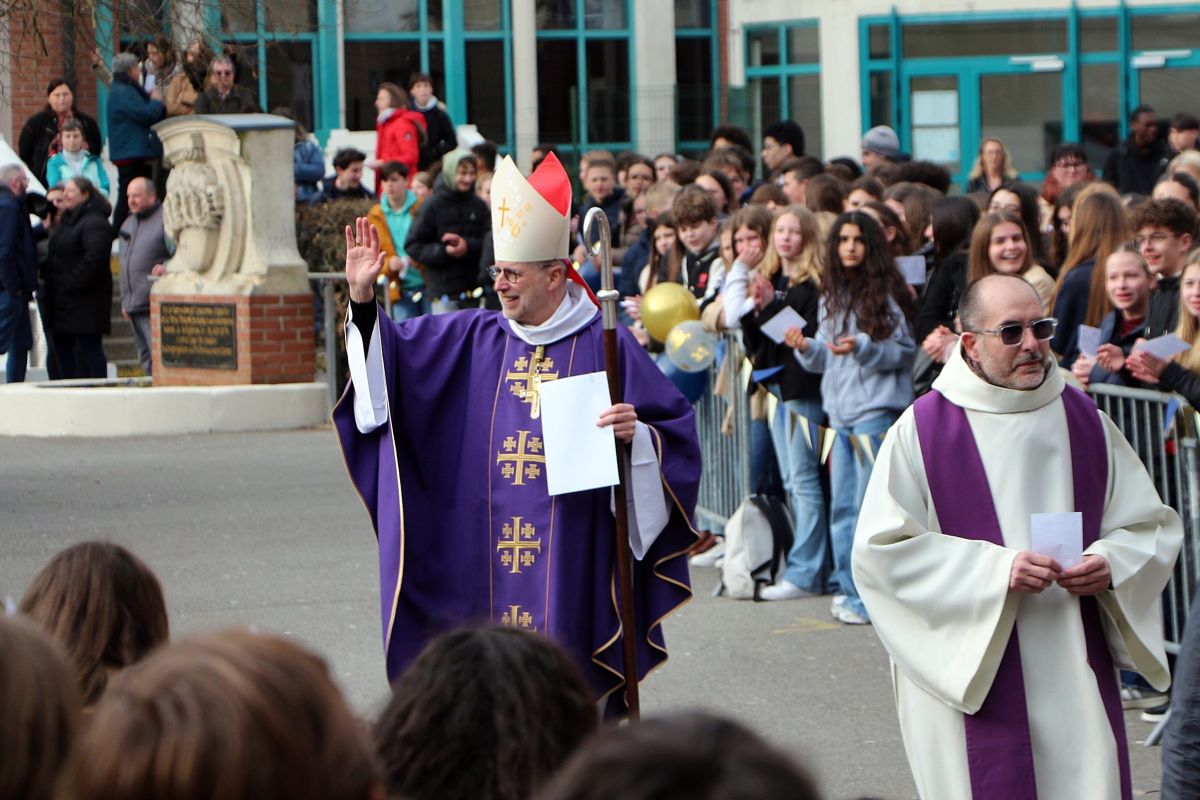 Évêque bénissant la foule d'élèves lors d'une cérémonie devant l'établissement