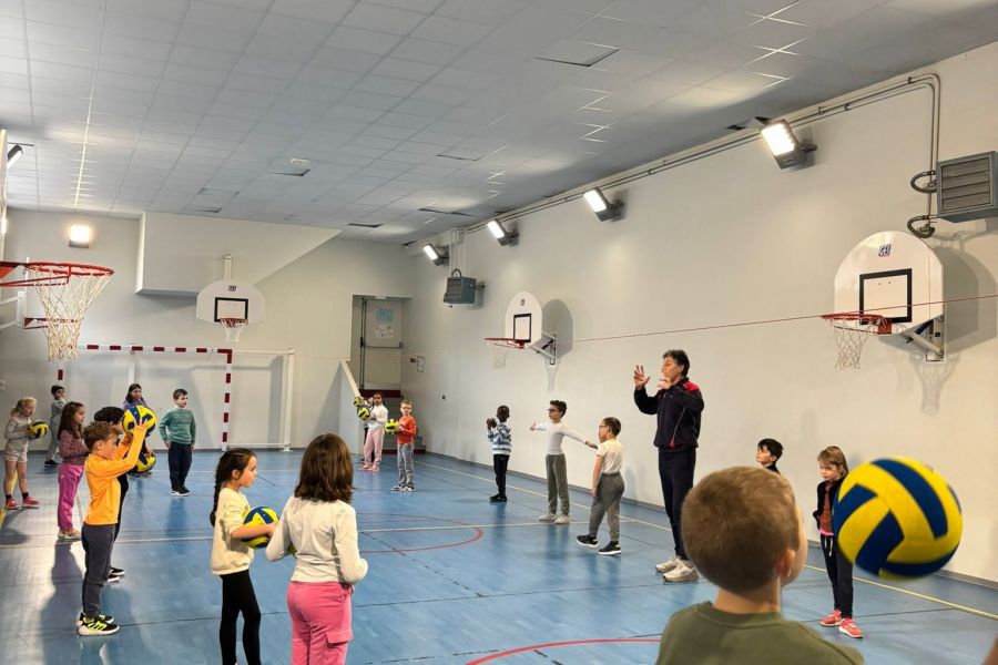 Enfants de l'école pratiquant des jeux de ballon dans le gymnase