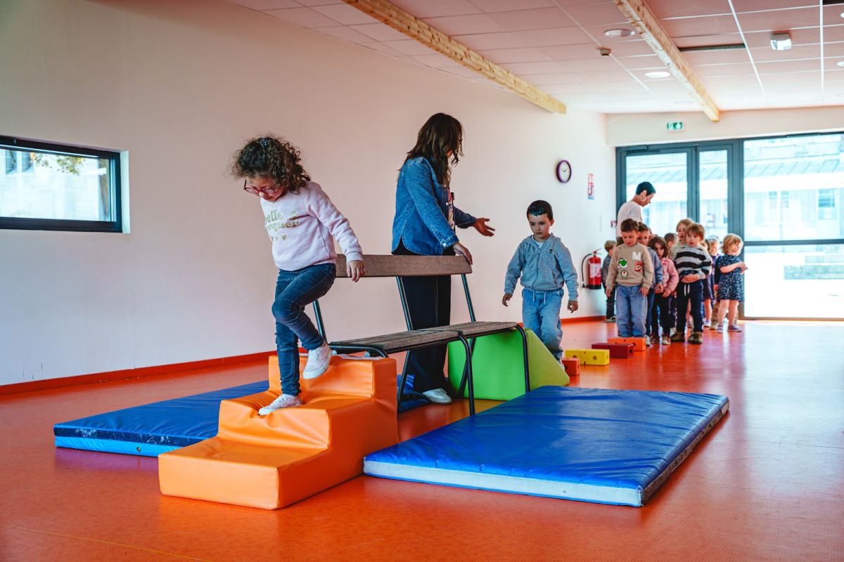 Enfants de maternelle sur un parcours de motricité en salle de sport