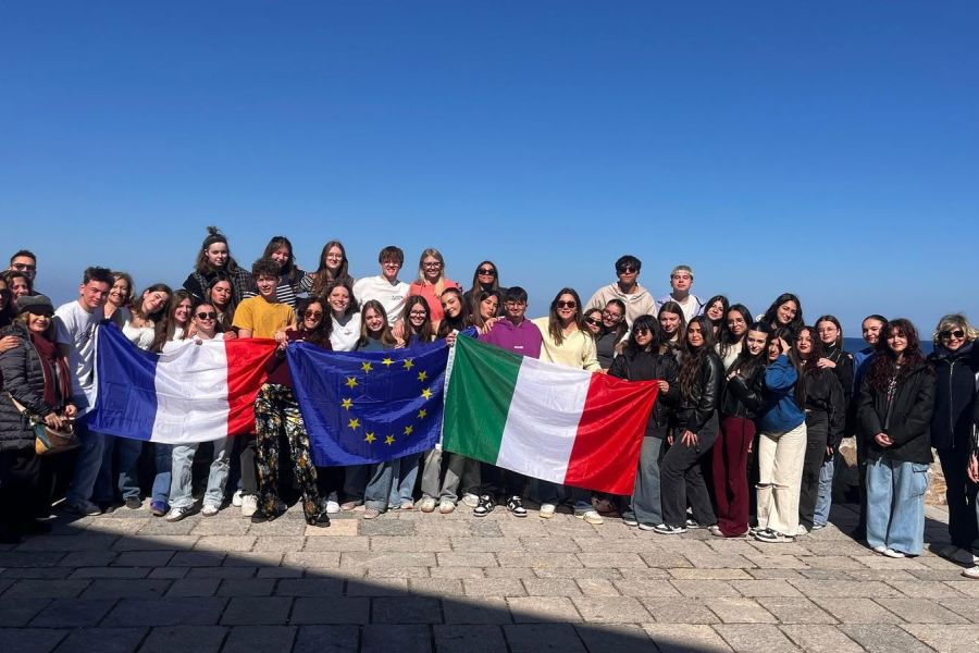 Élèves au bord de mer en Italie avec les drapeaux français, européen et italien