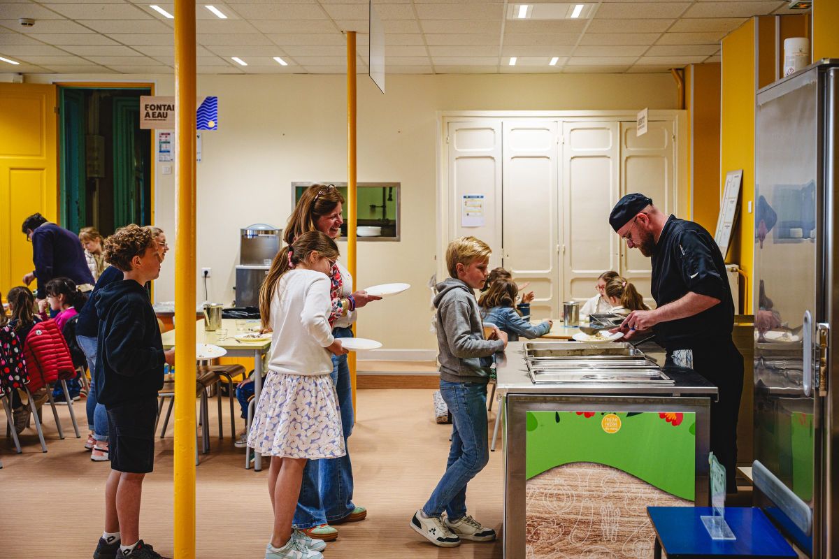 Élèves et personnel au self de l'école pendant le service du déjeuner