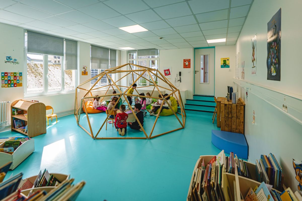Coin lecture avec cabane en bois dans la bibliothèque de l'école