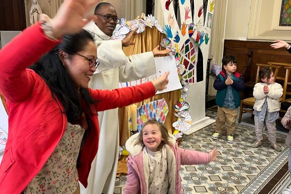 Célébration festive à l'église avec des enfants, leurs parents et le prêtre de l'école