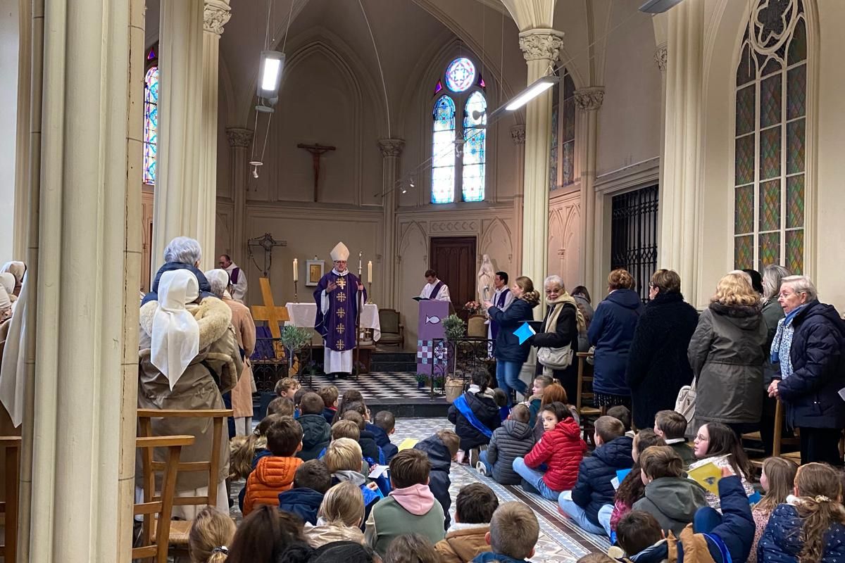 Célébration religieuse avec l'évêque et des enfants dans une chapelle