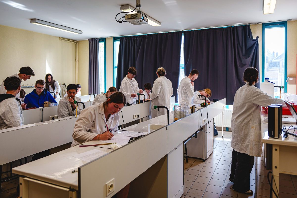 Lycéens en blouse blanche lors d'un TP de sciences en laboratoire