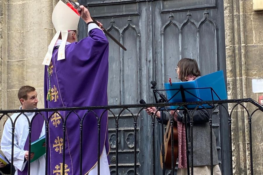 Évêque procédant à une bénédiction devant le portail d'une église