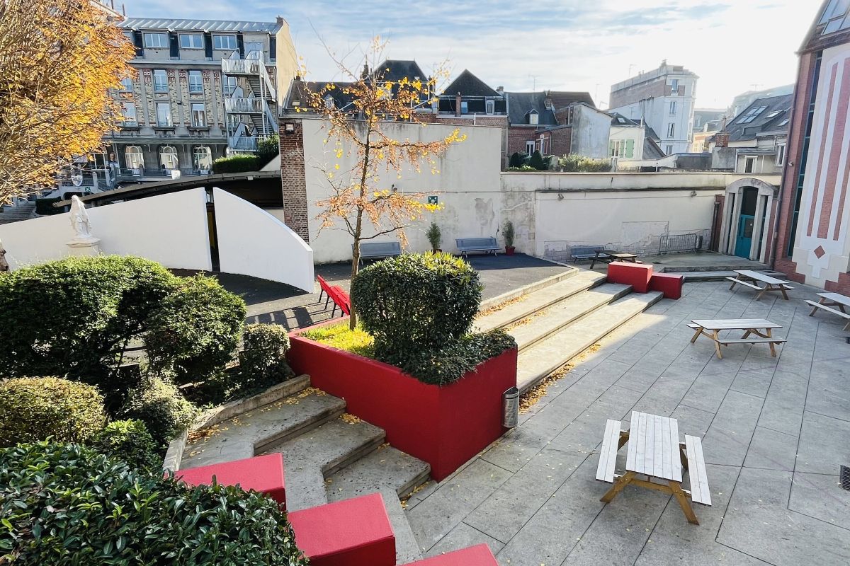 Cour intérieure du lycée avec bancs, jardin et vue sur les toits de Saint-Quentin