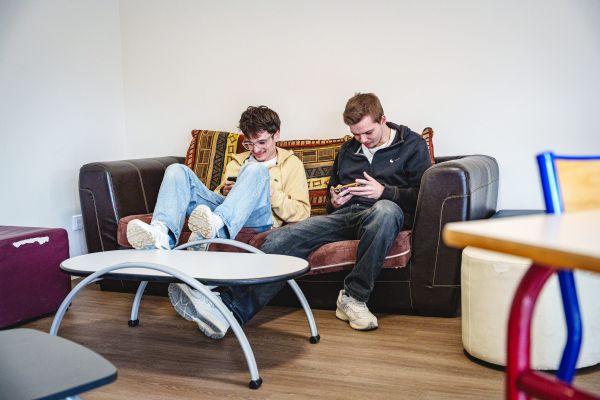 Étudiants détendus sur un canapé dans un espace de vie du Sup' Saint Jean & la Croix