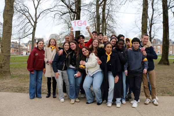 Lycéens réunis dans un parc avec une pancarte de classe pour un événement
