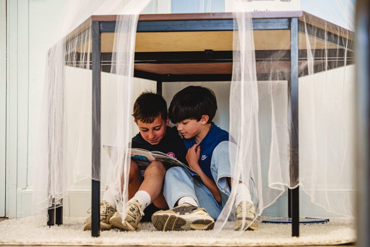 Deux élèves installés dans un coin lecture cocooning de l'école Saint Jean & la Croix