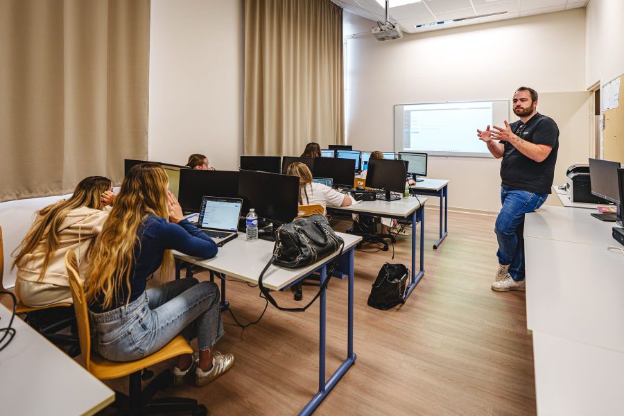 Formateur donnant un cours en salle informatique du Bachelor Communication