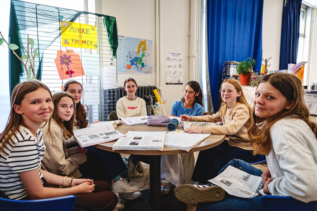 Collégiennes réunies autour d'une table pour un atelier de poésie