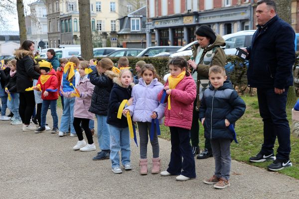 Écoliers en foulards colorés alignés dans la rue pour un événement festif
