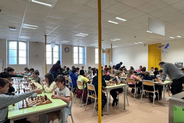 Tournoi d'échecs scolaire réunissant de nombreux élèves autour des échiquiers