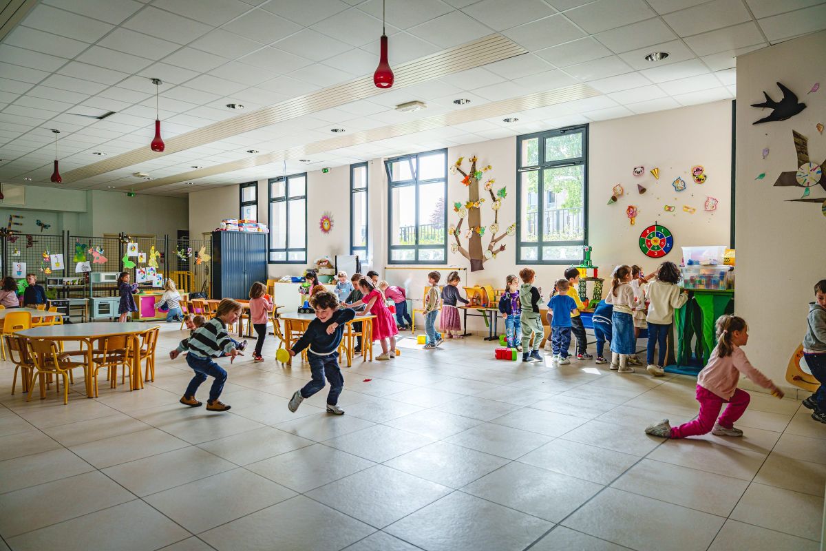 Enfants jouant librement dans la salle de garderie périscolaire