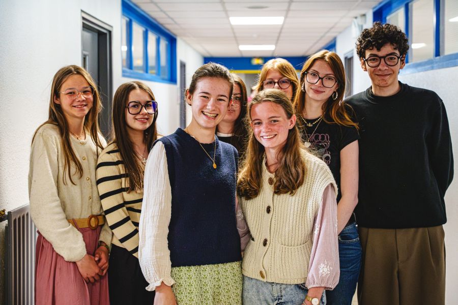 Groupe de lycéens souriants dans un couloir de l'établissement
