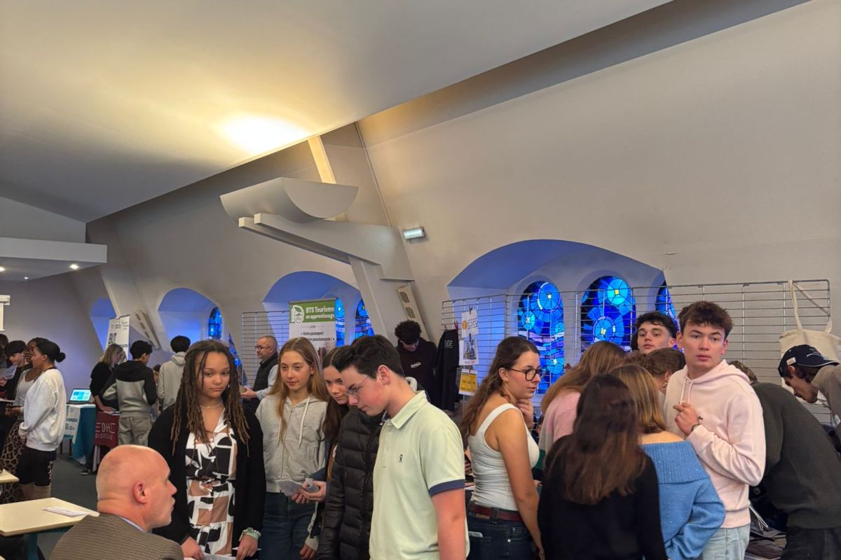Lycéens échangeant avec des exposants lors d'un forum de l'orientation