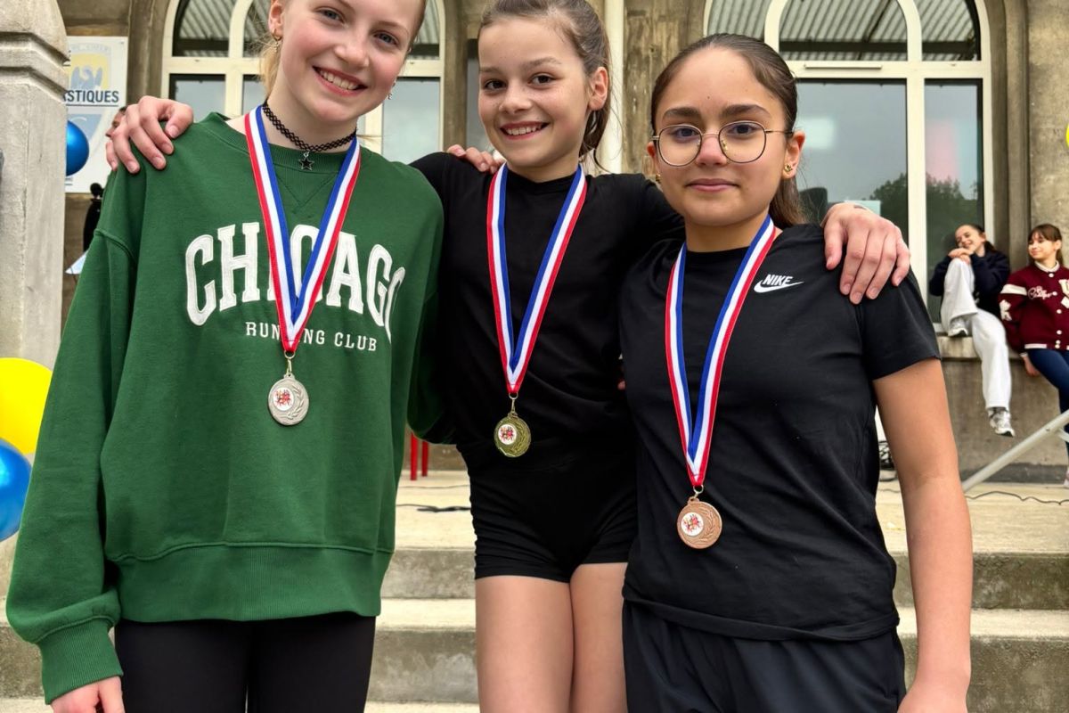 Trois collégiennes médaillées posant après une compétition sportive