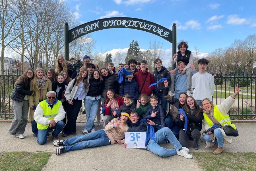 Groupe de collégiens souriant devant l'entrée du jardin d'horticulture lors d'une sortie