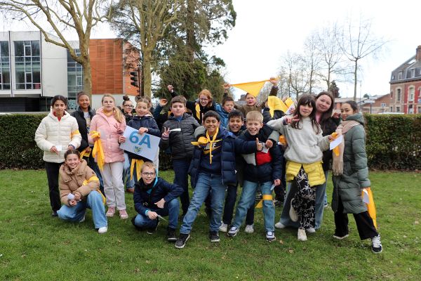 Groupe de collégiens posant avec une pancarte de classe lors d'un événement