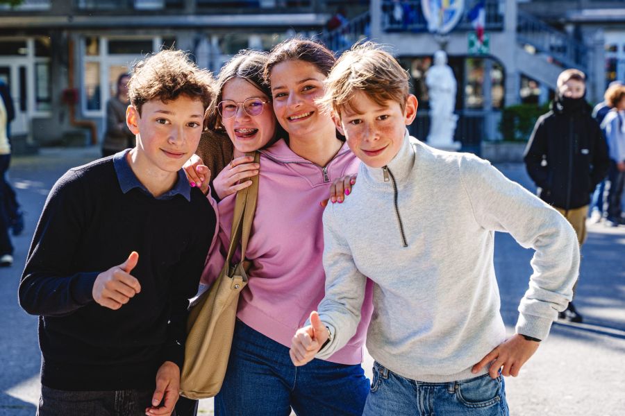 Collégiens souriants et complices dans la cour de l'établissement
