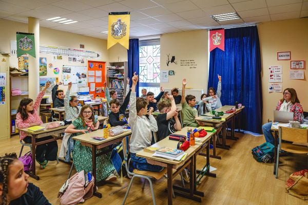 Élèves levant la main en classe décorée aux couleurs d'Harry Potter