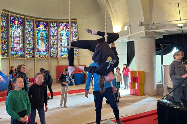 Élève suspendue à un trapèze lors d'un cours de cirque avec la Compagnie Isis