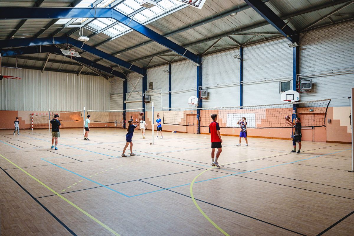 Élèves pratiquant le badminton dans le gymnase de l'association sportive