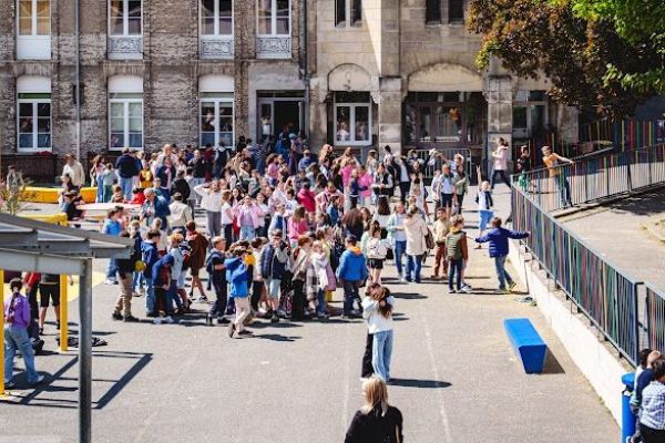 Élèves de maternelle rassemblés dans la cour de l'école pour la rentrée