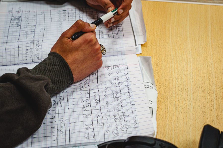 Étudiant réalisant des calculs à la main avec une calculatrice en BTS Gestion de la PME